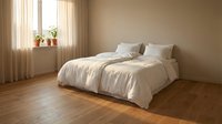 Minimalist bedroom interior with unmade bed, white linens, wooden floor, beige walls, natural window light and small potted plants on windowsill.