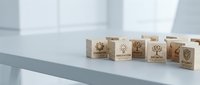 Wooden blocks with environmental sustainability symbols arranged on modern office desk for eco-friendly business concept and green marketing materials.