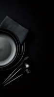 Empty skillet with kitchen utensils and cloth napkin on dark background, overhead view for cooking, culinary, and food preparation design projects.