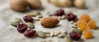 Healthy mix of nuts, dried fruits and seeds scattered on rustic burlap fabric. Natural organic snack ingredients for trail mix, granola or healthy eating lifestyle.