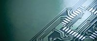 Close-up macro view of green circuit board with intricate electronic pathways and microchip components for technology and engineering applications.