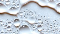 Water drops on white surface creating abstract pattern with light and shadow play. Pure and minimalist macro photography showing surface tension and natural geometry.