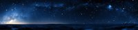 Panoramic starry night sky over dark horizon with glowing stars, nebula and milky way galaxy reflecting on calm water surface at twilight.