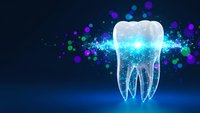Glowing tooth with digital particles on dark blue background for dental care, oral health and medical technology concepts.