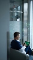 Professional businessman using tablet with digital interface in modern office environment for technology and business applications.