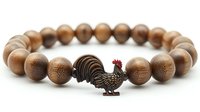Wooden bead bracelet with decorative rooster charm on white background, natural brown sandalwood beads and bronze metal accent for spiritual jewelry design.