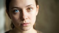 Close-up portrait of young Caucasian woman with heterochromia showing one blue and one brown eye, natural lighting for medical or genetic diversity concepts.
