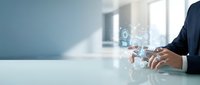 Professional businessman using digital technology interface with holographic icons and data visualization in modern office environment for business innovation.