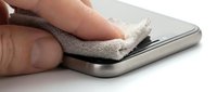 Hand cleaning smartphone screen with microfiber cloth, removing dust and fingerprints from mobile device display for maintenance and hygiene purposes.