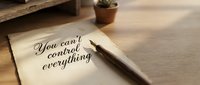 You can't control everything motivational quote written on paper with pen on wooden desk workspace for personal development and mindfulness practice.
