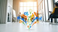 Young diverse professionals in casual business attire collaborating in modern office space with creative innovation icons floating above, representing teamwork and strategic planning.