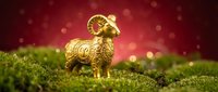 Golden ram figurine standing on moss with red bokeh background, suitable for festive decorations and holiday designs.
