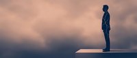 Silhouetted male figure standing on floating platform against dramatic cloudy sky at sunset, representing ambition, leadership, and success in business and personal growth.