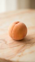 Fresh ripe apricot with fuzzy skin placed on wooden surface with natural lighting, suitable for food photography, culinary content, and healthy eating concepts.