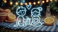 Glowing neon couple figures on romantic picnic setting with string lights, citrus slices and checkered blanket creating cozy outdoor atmosphere.