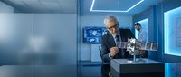 Senior male professional in business suit examining satellite model in modern tech laboratory with blue lighting and digital displays.