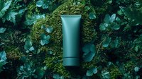 Minimalist green cosmetic tube on natural moss and leaves background. Clean skincare packaging mockup surrounded by lush forest vegetation and greenery.