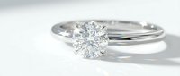 Elegant solitaire diamond engagement ring with brilliant cut stone set in polished white gold or platinum band on clean white background for jewelry design.