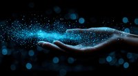 Glowing blue particles floating above an outstretched hand against dark background create magical ethereal effect, symbolizing innovation and digital transformation.