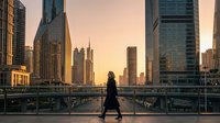 Woman jogging on urban bridge at sunrise with modern skyscrapers in background, fitness and city lifestyle concept for wellness and active living.