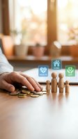 Hand protecting wooden family figures and coins with health, home, life insurance icons for financial security planning and family protection concept.