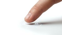 Human finger touching white surface creating ripple effect on clean minimalist background for technology and interaction concepts.