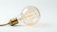 Vintage incandescent bulb with warm filament glow isolated on white background, ready for design projects, web graphics, and lighting concept illustrations.