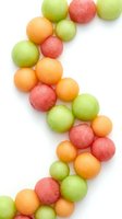 Colorful round candy balls in green, orange and pink arranged on white background isolated for confectionery and sweet treat designs.