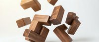 Wooden puzzle blocks falling and floating in mid-air against white background, showcasing natural wood grain texture for educational games and brain training.