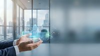 Businessman holding smartphone with digital financial charts and data analytics hologram in modern office space for business technology and investment concepts.