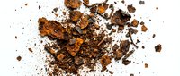 Crushed chocolate pieces and cocoa powder scattered on white background, suitable for food photography, baking content, and culinary design projects.