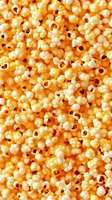 Buttery popcorn background with fluffy white kernels and golden yellow texture, filling frame completely for food and entertainment concepts.