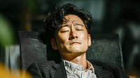 Asian businessman relaxing in office chair with eyes closed, taking break from work stress. Professional male executive resting during busy workday.
