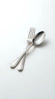 Shiny stainless steel fork and spoon crossed on white background, isolated cutlery set for restaurant, kitchen, and dining design use.