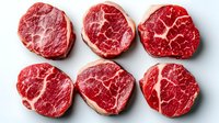 Fresh raw beef tenderloin steaks with marbling pattern arranged in two rows on white background, premium cut meat for restaurant menu and cooking.