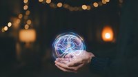 Glowing brain hologram floating above open palm with warm bokeh lights creating magical atmosphere for technology and innovation concepts.