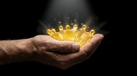 Male hand holding glowing golden light burst with sparkling particles on black background. Concept for success, wealth, opportunity, and achievement in business and personal growth.