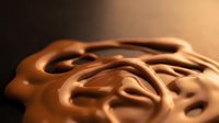 Smooth melted chocolate with swirled texture and glossy finish, ideal for food, confectionery, and dessert marketing materials.