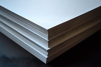 Stack of white paper sheets with layered edges creating diagonal lines and shadows against dark background, suitable for business and office concepts.