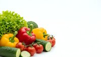 Fresh organic vegetables including bell peppers, tomatoes, cucumbers and lettuce isolated on white background for healthy cooking and nutrition concepts.