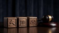 Wooden blocks with legal symbols including scales of justice, courthouse and gavel on dark background representing law, legal services and judicial system.