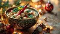 Asian soup with noodles and meat in traditional ornate bowl surrounded by Christmas decorations, red baubles and glowing lights on dark background.