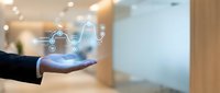 Businessman hand holding glowing cloud computing icon with connected network symbols in modern office environment for digital transformation and data storage solutions.