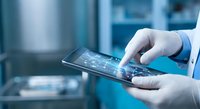 Medical professional using digital tablet with healthcare interface in modern clinical environment for patient data management and telemedicine applications.