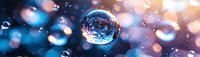 Crystal clear water droplet suspended against blurred blue and golden bokeh background, creating dreamy atmospheric effect for nature photography.