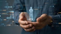 Businessman hands holding glowing holographic human figure with digital network connections and data visualization for HR technology and workforce management.