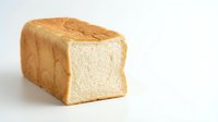 Fresh baked white bread loaf with soft fluffy texture isolated on white background for bakery menu design and food photography projects.