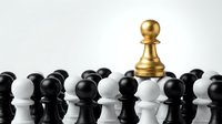 Golden pawn standing out among black and white chess pieces on reflective surface, symbolizing leadership, strategy, and unique thinking in business.