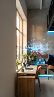 Businessman holding holographic city model with glowing buildings in modern office space showcasing smart city technology and urban planning innovation.