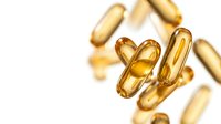Golden omega-3 fish oil capsules floating on white background. Dietary supplements for heart health, brain function and wellness nutrition.